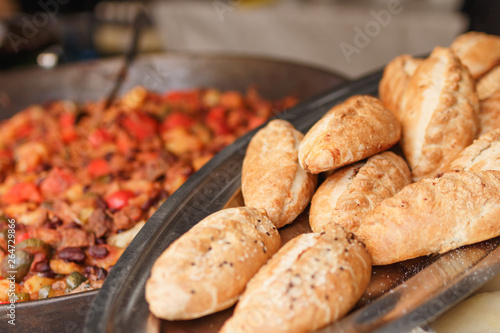 Fresh backed baguette bread with other meal background at the street food festival. Selective focus