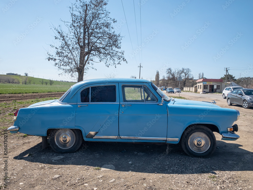 Sevastopol, Republic of Crimea - March 23, 2019: Blue old soviet car GAZ M21 Volga / GAZ-21 oldtimer parked on the road in spring sunny weather  