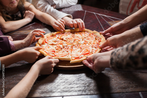 children eat pizza in a restaurant.