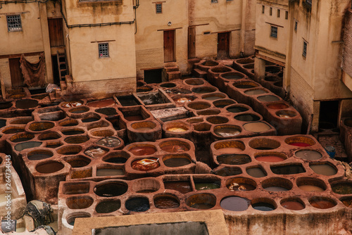 View inside of old medina in Fes, a traditional and old tannery with workers working making methods of leather in the city Fes, Morocco, in april of 2019.  photo