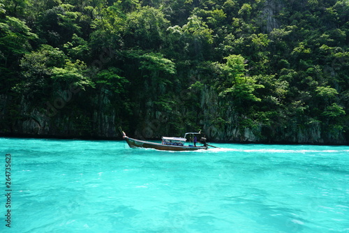 Longtail boat on tropical island in thailand crystal clear water