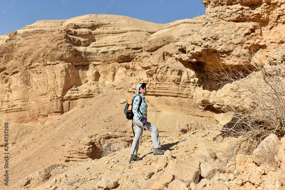 Middle-aged woman hiking on scenic route in wadi Heymar, Judea desert, Israel