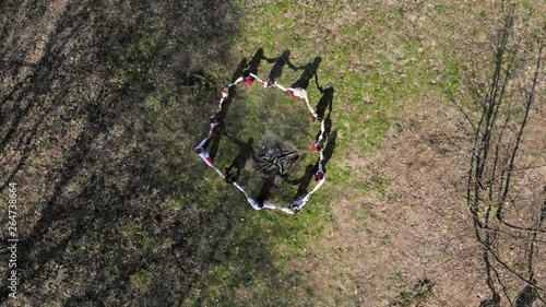 Aerail view on top. Group of children dancing around the fire holding hands photo