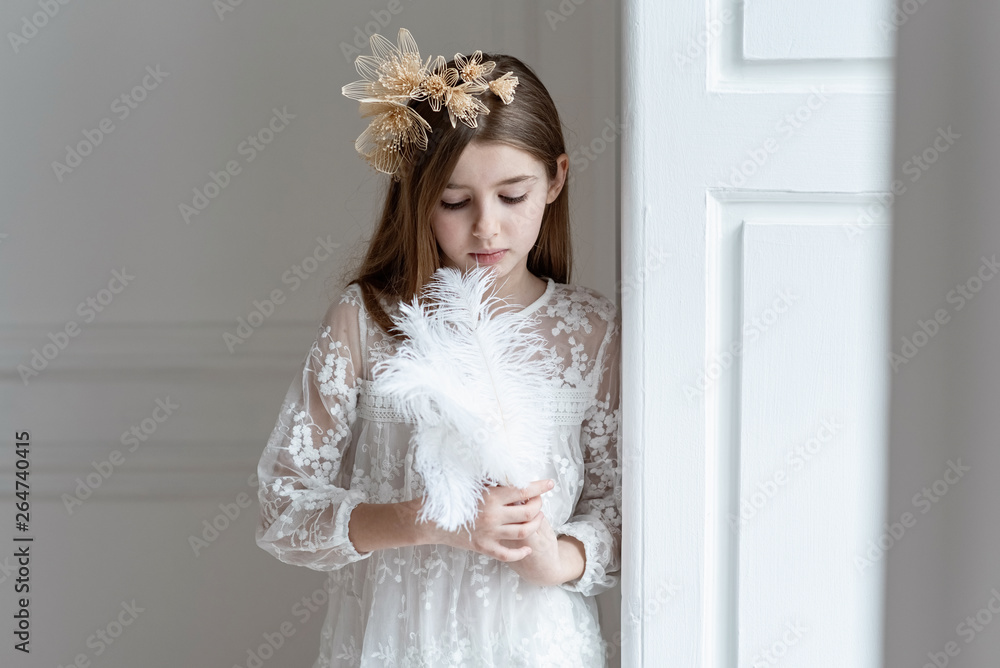 The girl thoughtfully holds a big white feather The girl thoughtfully holds a big white feather
