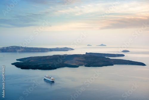 Cruise ship nearby small islands in the sea. Santorini, Greece