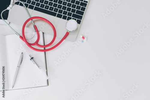 Medical healthcare backgrounds flat lay objects with copy space. Doctor stethoscope, medicine, laptop computer and notebook on white office table. photo