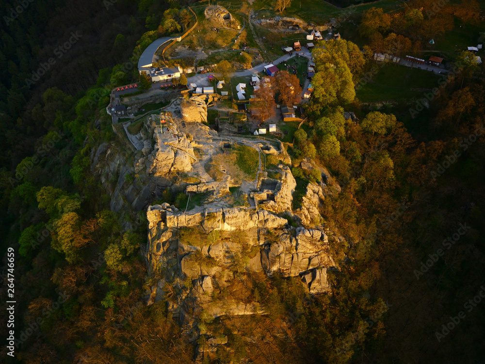 Medieval Regenstein Castle in the Harz mountains, aerial view. Ruined castle near Blankenburg, Saxony-Anhalt, Germany. Beautifully sunlit by the evening sun in springtime during festival season.