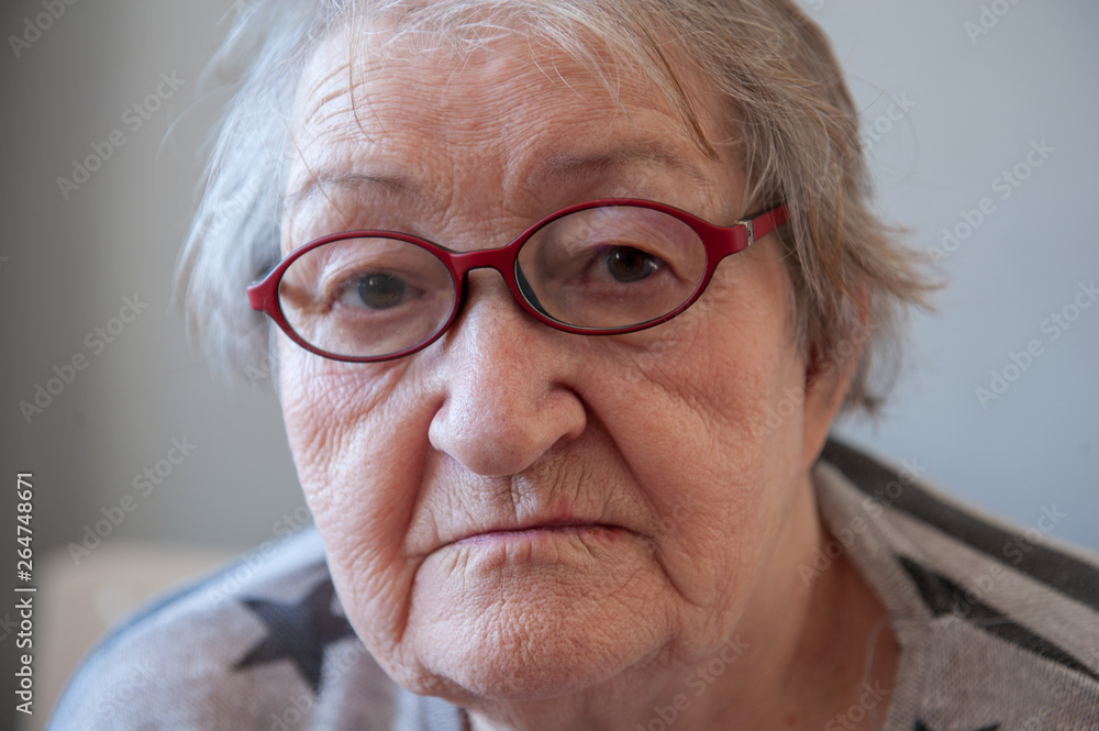 Elderly woman with beautiful face in wrinkles with gray hair with glasses. Closeup portrait. Grandmother Retired waiting for social assistance. Elderly woman with beautiful face in wrinkles with gray hair with glasses. Closeup portrait. Grandmother Retired waiting for social assistance.