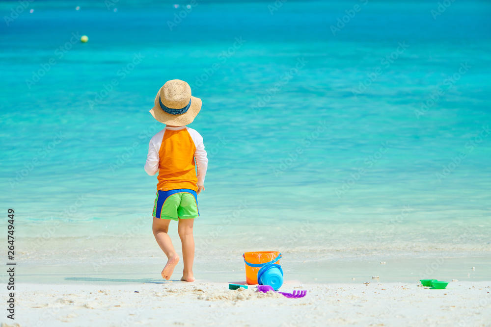 Three year old toddler playing on beach Three year old toddler playing on beach