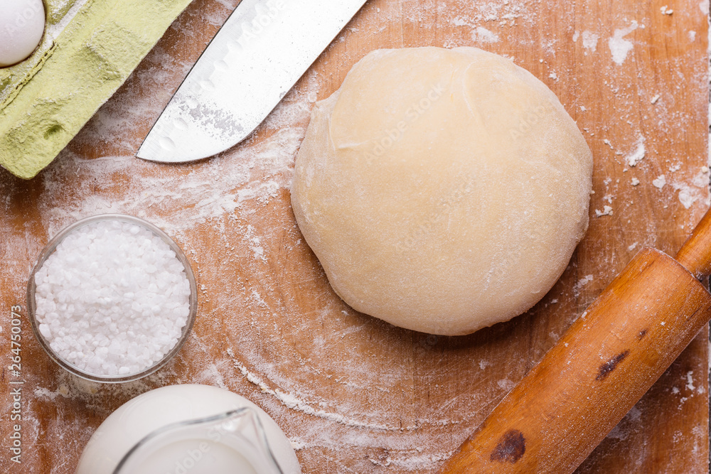 young woman in apron kneading dough on board young woman in apron kneading dough on board