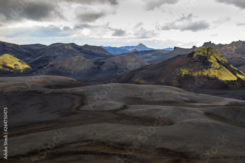 Dramatic iceland landscape with a green hill and black lava looks like a moon. Serenity of Iceland.