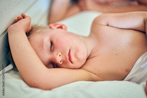 Toddler boy sleeping on pillow with mother