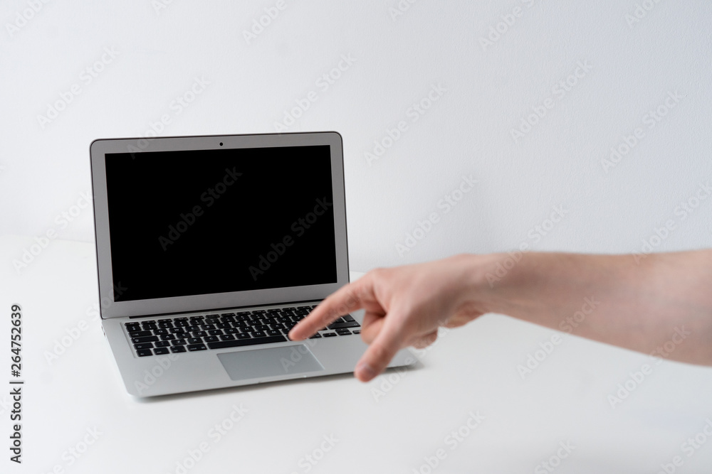 Open laptop with finger pointing on the desk with white background Open laptop with finger pointing on the desk with white background