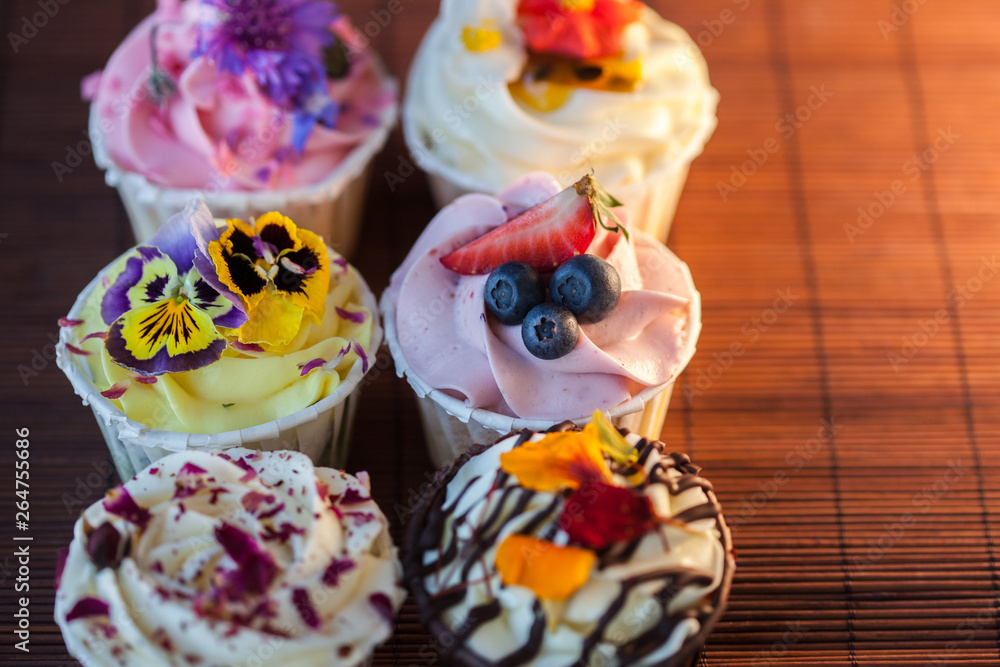Beautiful and delicious cupcakes on the table. A set of delicious sweet desserts