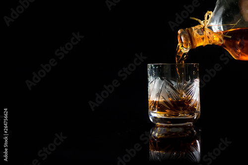 glass of whiskey with ice isolated on black background