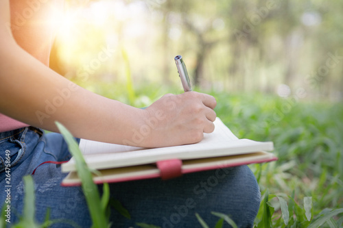 poem, poetry and knowledge education concept,  close up sitting writing on notebook in park