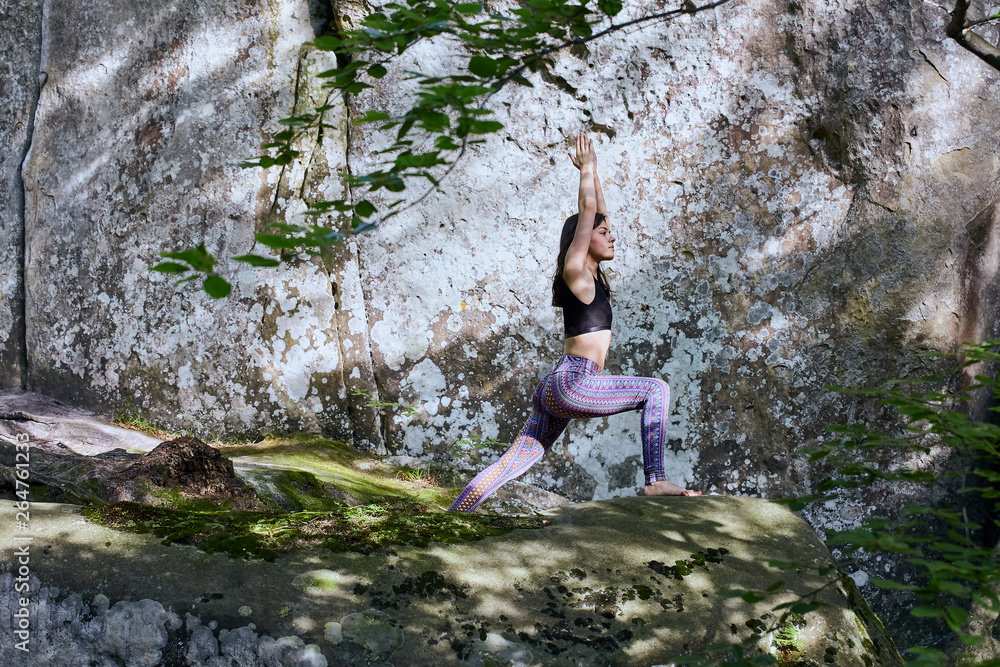 Young girl in mountains doing yoga exercise outdoor.