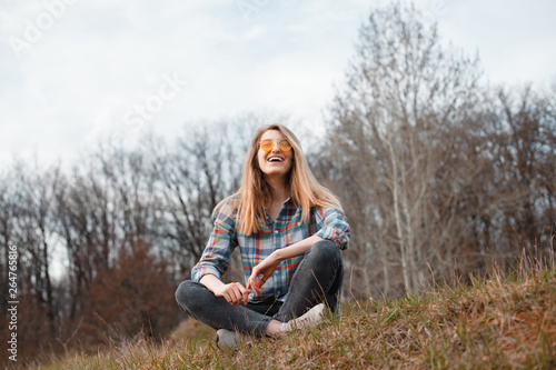 Young woman sitting on the hill and laughing