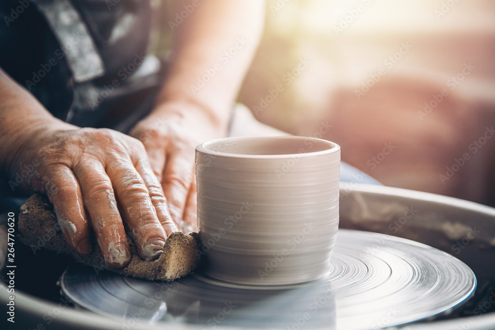 Master on potter wheel makes clay dishes. Workshop place Master on potter wheel makes clay dishes. Workshop place