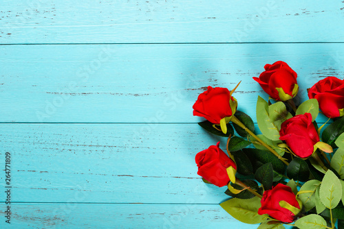 roses on blue wood background with copy space