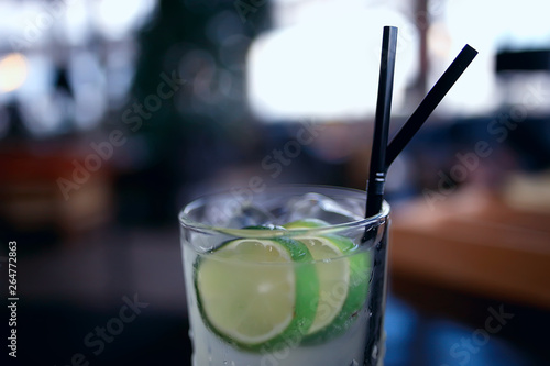 lemonade in glass cafe / fresh lemonade with ice and lime in a glass on a restaurant background
