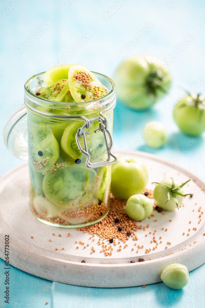 Closeup of natural pickled green tomatoes in the jar Closeup of natural pickled green tomatoes in the jar
