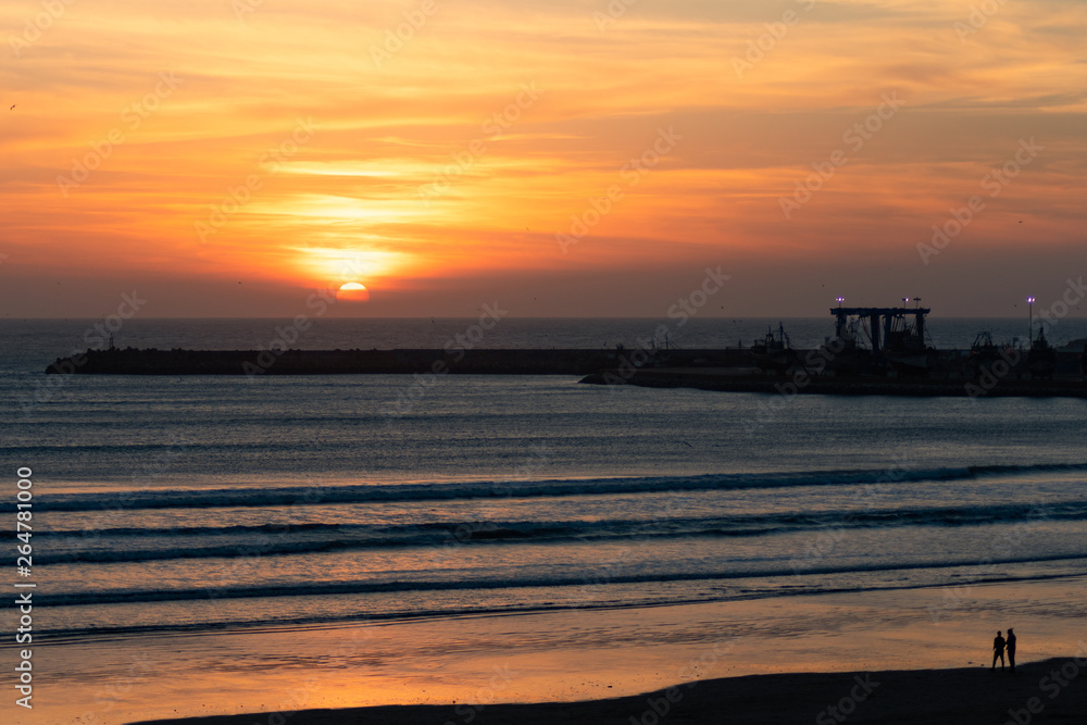 Sunset on the Beach in Essaouira Morocco near the Horizon with Waves and the Shipyard