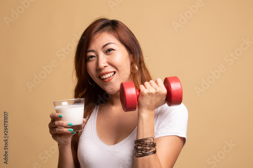 Healthy Asian woman drinking a glass of milk and dumbbell.