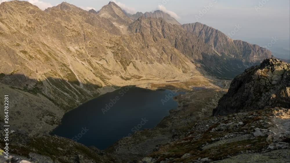 Shadow moving over Velke Hincovo pleso, mountain lake of glacial origin in Slovakian High Tatras. Around 2000 m above sea level. Time lapse. Shadow moving over Velke Hincovo pleso, mountain lake of glacial origin in Slovakian High Tatras. Around 2000 m above sea level. Time lapse.