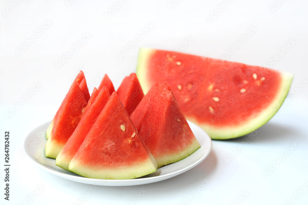 Red watermelon slices on white plate over white background, selective focus Red watermelon slices on white plate over white background, selective focus