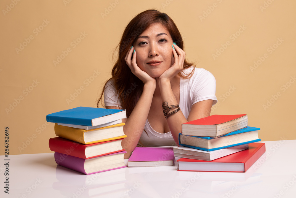 Young Asian woman read a book with books on table. Young Asian woman read a book with books on table.