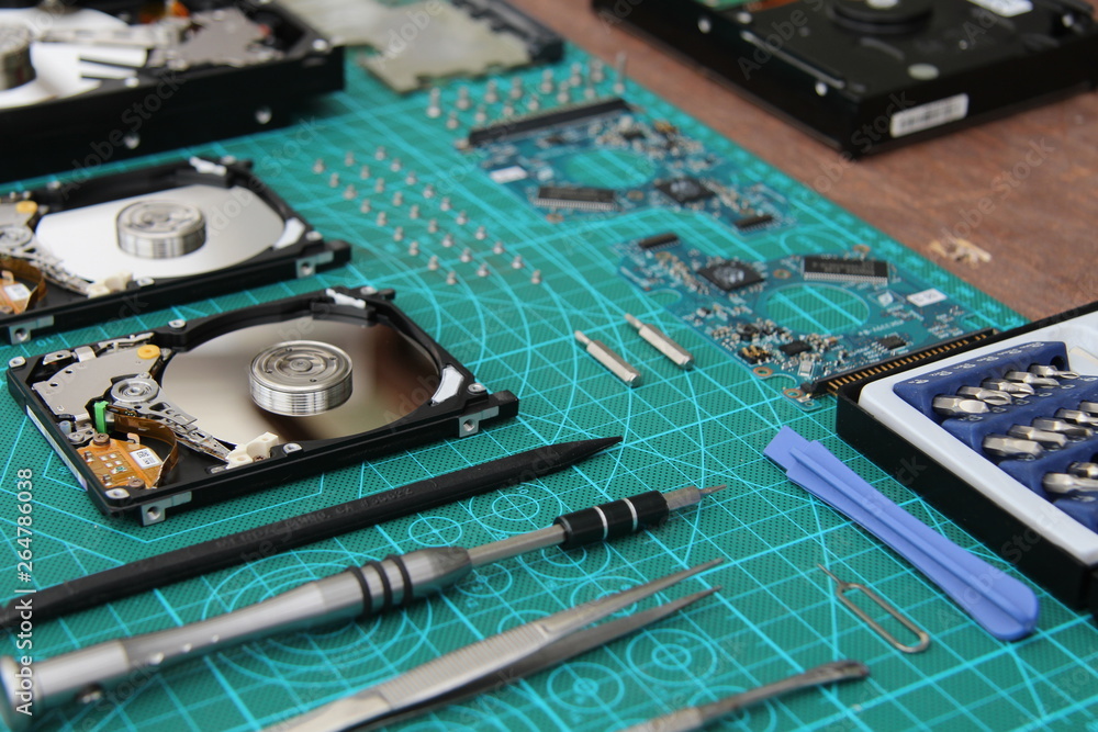 the hard drive is disassembled on the table with tools the hard drive is disassembled on the table with tools