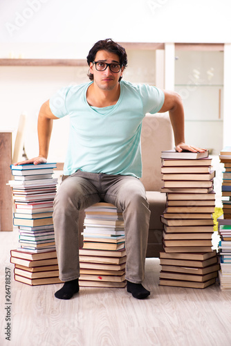 Male student with many books at home 