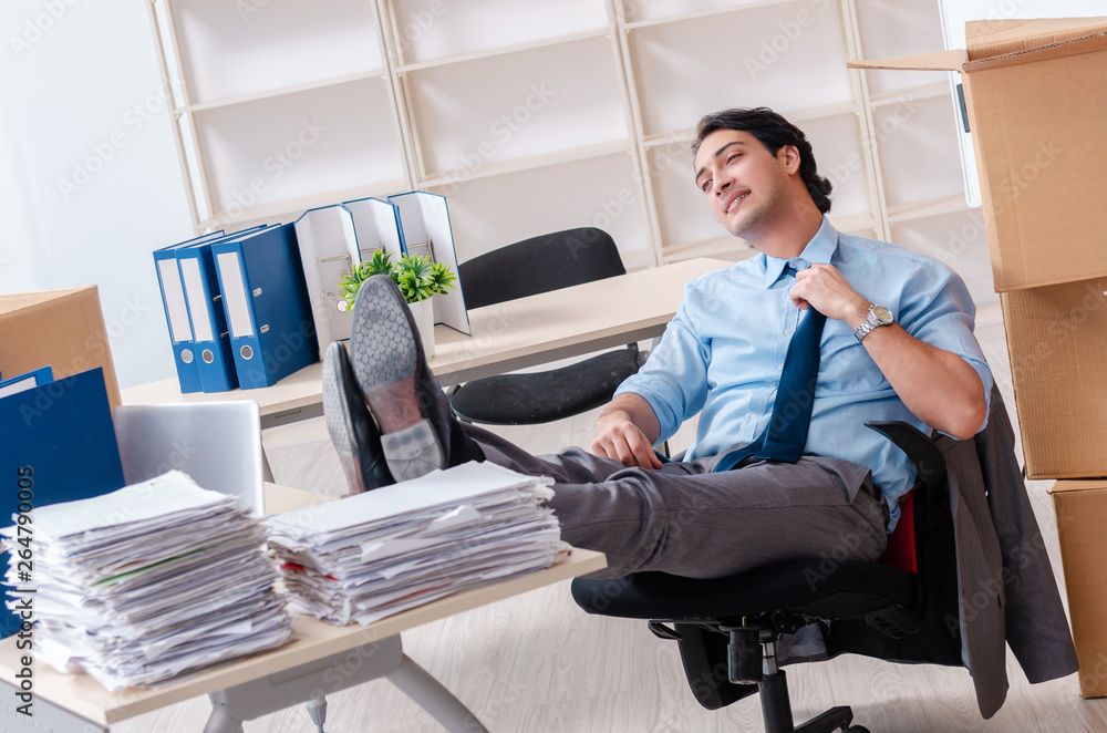 Young man employee with boxes in the office Young man employee with boxes in the office