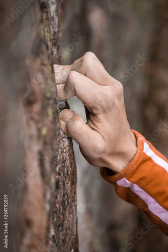 Man full crimping a hold climbing