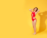 beautiful girl in red swimsuit on yellow background