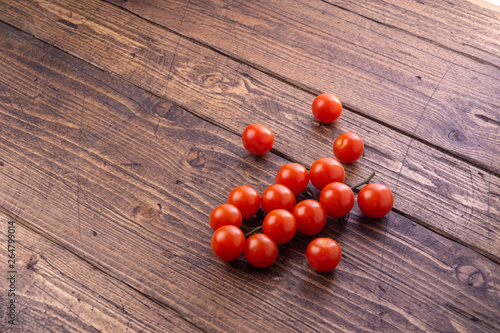 Fresh ripe garden tomatoes lying on wooden table. Side view with copy space.