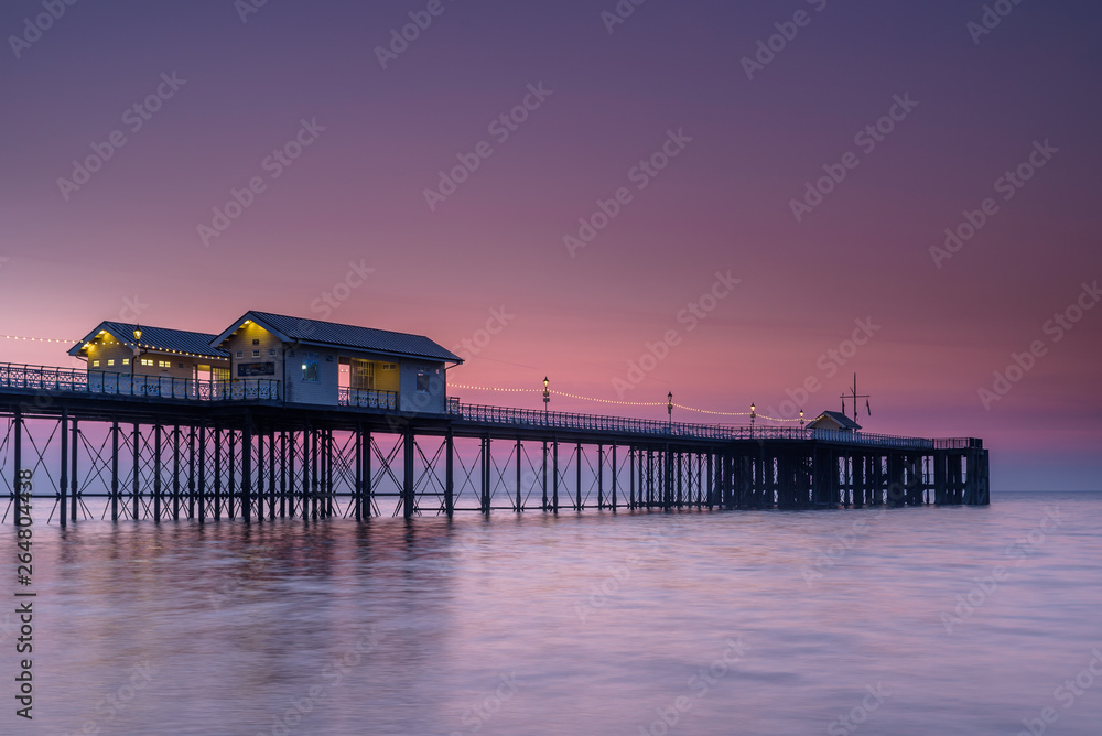 Penarth Pier, on the south Wales coast, near Cardiff, at sunrise. The sky is red and orange, and the sea is smooth Penarth Pier, on the south Wales coast, near Cardiff, at sunrise. The sky is red and orange, and the sea is smooth