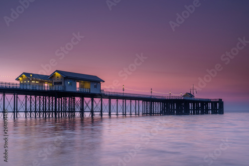 Penarth Pier, on the south Wales coast, near Cardiff, at sunrise. The sky is red and orange, and the sea is smooth photo