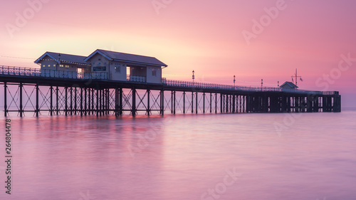 Penarth Pier, on the south Wales coast, near Cardiff, at sunrise. The sky is red and orange, and the sea is smooth © parkerspics