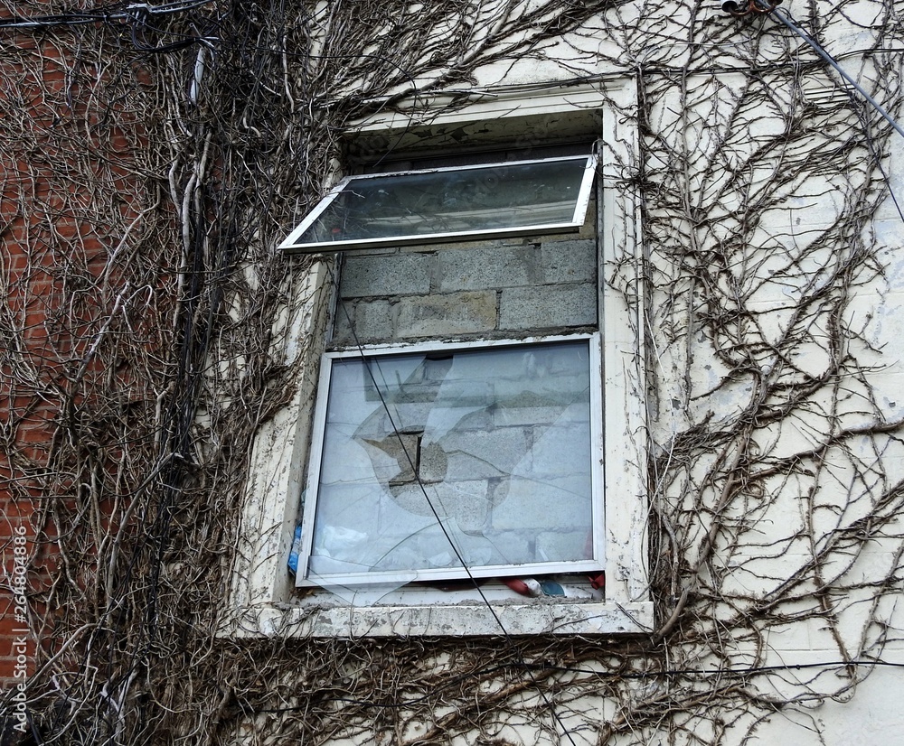 Broken window boarded up with cement bricks in derelict building. Broken window boarded up with cement bricks in derelict building.