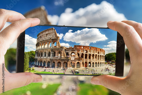 Tourist taking photo of Colosseum with mobile phone, Rome, Italy photo