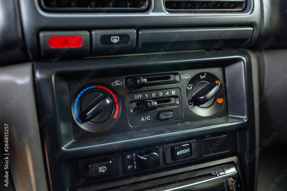 Old Japanese made sports car interior center dashboard with climate control knobs.