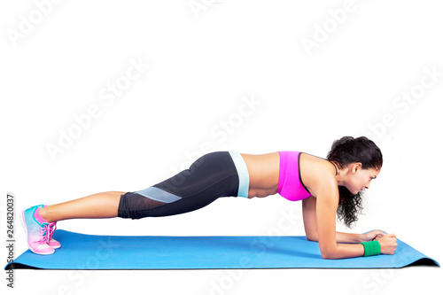 Indian woman doing plank exercises on studio