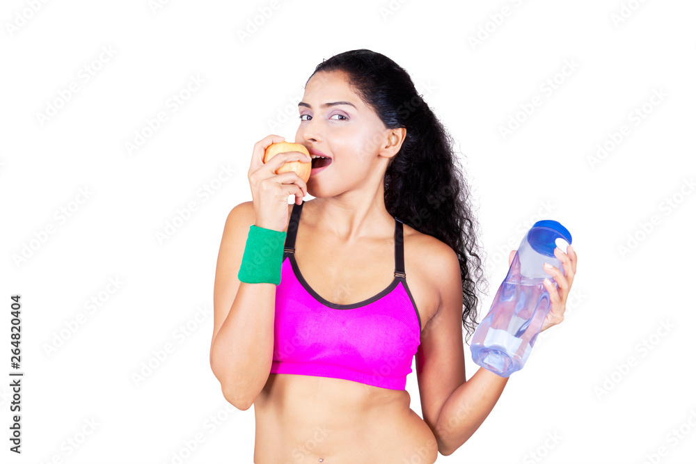 Indian woman with apple and bottle on studio Indian woman with apple and bottle on studio