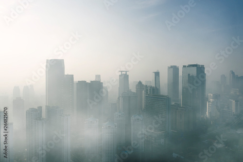 Modern high buildings covered by fog