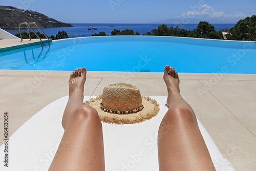 Legs Sunbathing on Lounger Near Swimming Pool. Isolated.