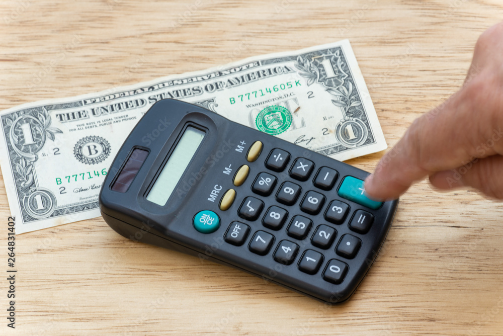person making account, in a pocket calculator with a wooden background. person making account, in a pocket calculator with a wooden background.