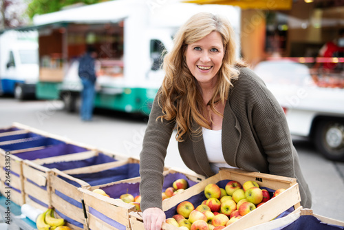 Marktfrau verkauft Äpfel auf dem Wochenmarkt 