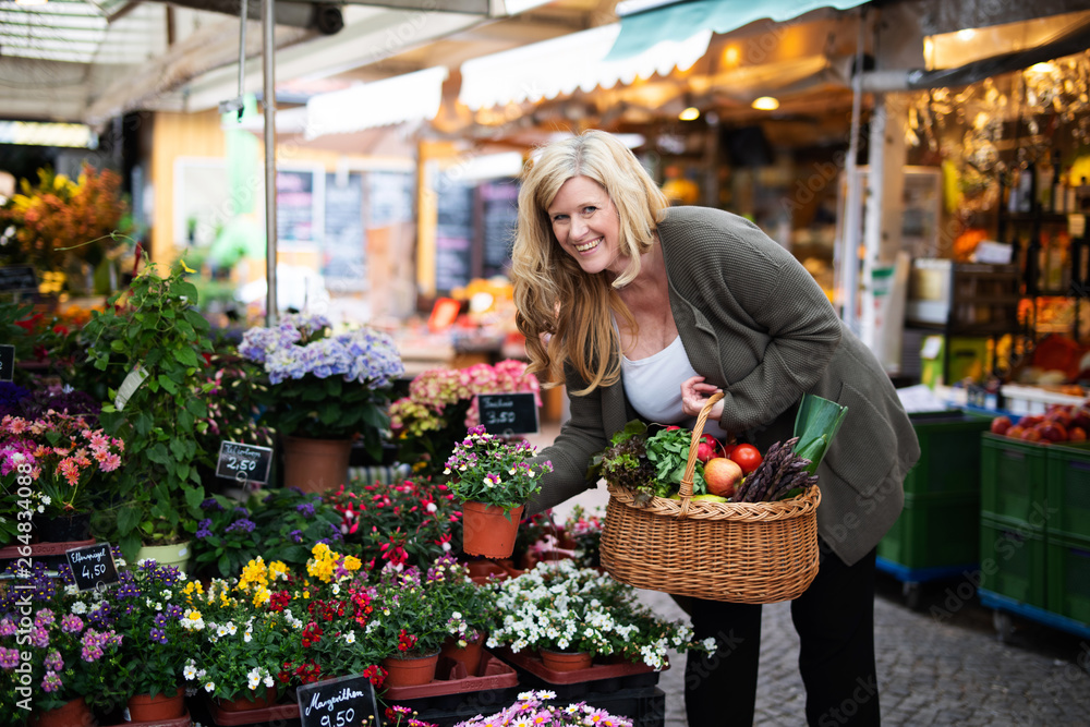 Frau freudig lachend kauft Blumen auf dem Markt Frau freudig lachend kauft Blumen auf dem Markt